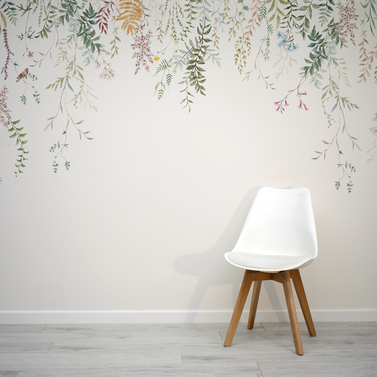 Simple white chair with a plain white wallpaper with hanging florals.