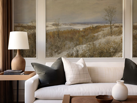 Living room with a beige sofa, decorative pillows, a lamp, and a painting on the wall.