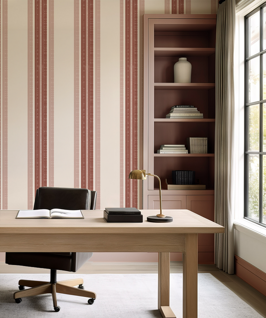 Modern office space with a desk, chair, and bookshelf against striped wallpaper.