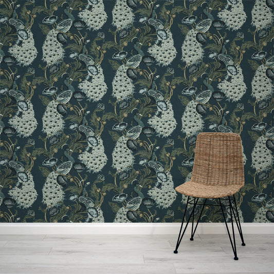 Wicker chair in front of a wall with decorative floral peacock wallpaper