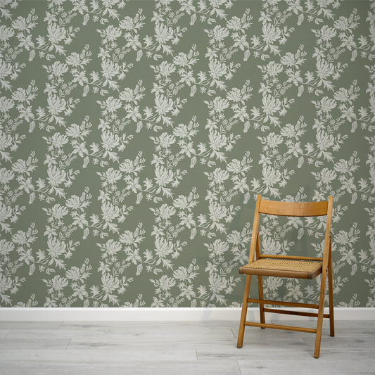Wooden chair against a green wall with floral pattern