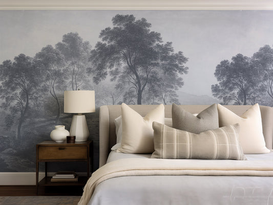 Bedroom with a large wall mural of trees, a bed with pillows, and a lamp on a nightstand.