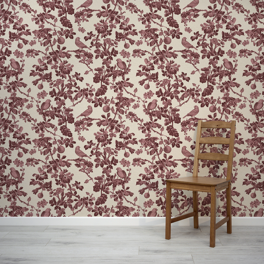 Wooden chair against a wall with floral and bird patterned wallpaper