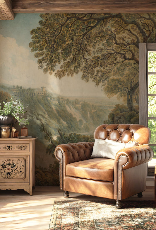 Amalia Wallpaper with a Brown leather armchair in a room with a large wall mural of a landscape.