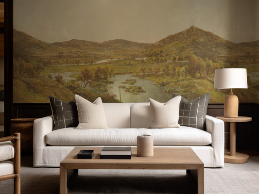 Living room with a white sofa, wooden coffee table, and scenic wall art.