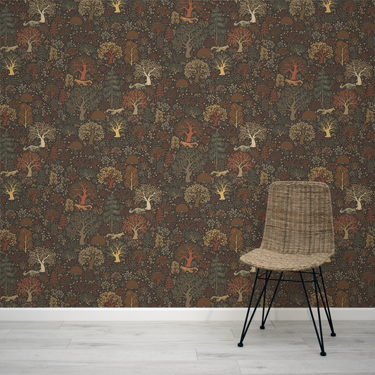 Woven chair in front of a forest-themed wallpaper with trees and animals.