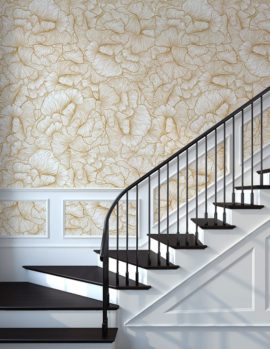Chanterelle Gold Wallpaper in a Staircase with black railing against a floral gold wall 