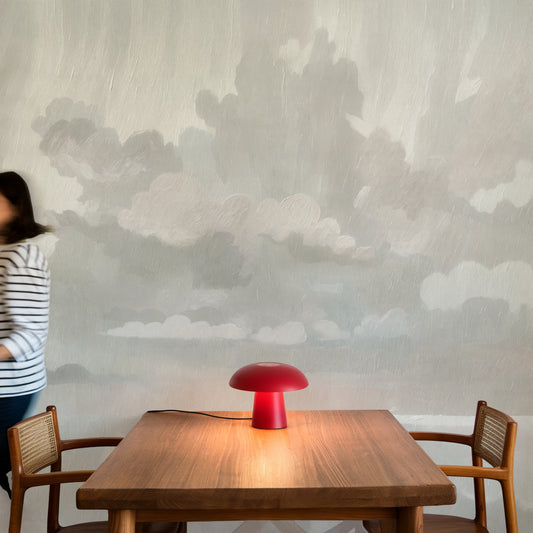 Red lamp on a wooden table with a person partially visible in the background