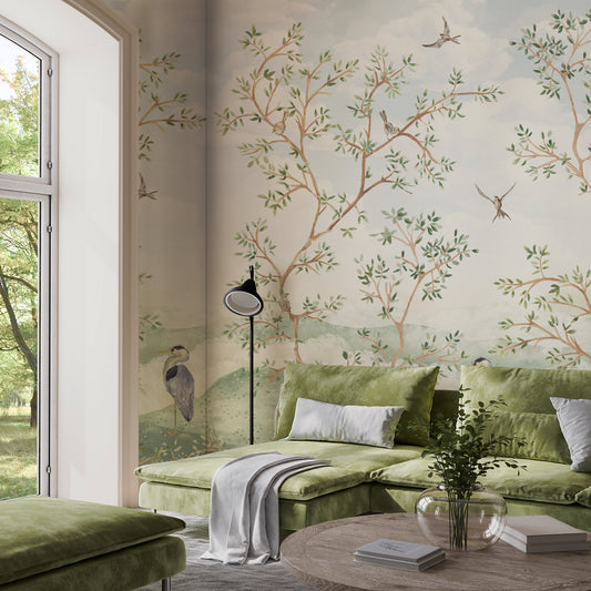 Living room with green sofa, decorative wall mural, and natural light.