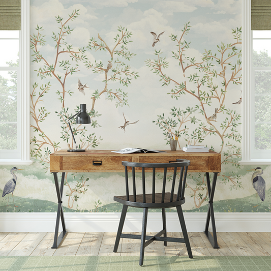 Wooden desk with black chair against a decorative wall with tree and bird pattern