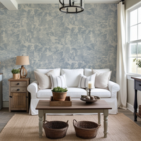 Living room with a white sofa, wooden coffee table, and patterned wallpaper.