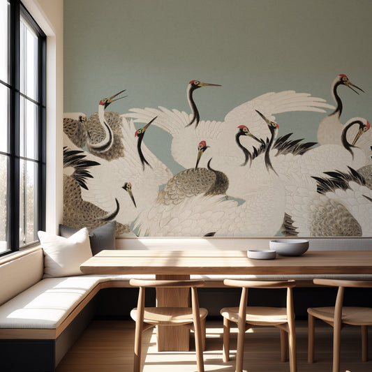 A large wall mural featuring elegant cranes in white, gray, and black with small red accents, displayed in a modern dining room setting with a wooden table and chairs.