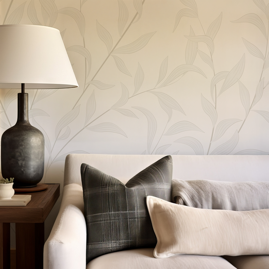 Living room with a sofa, lamp, and decorative pillows against a leaf-patterned wall.