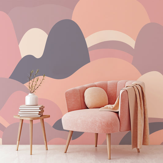 Mellow Curved Horizons wallpaper in lounge with pink soft chair with wooden stool in front of chair with books and plant pot on top