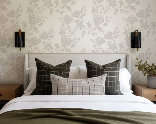 Bedroom with a bed featuring patterned pillows against a floral wallpaper wall.