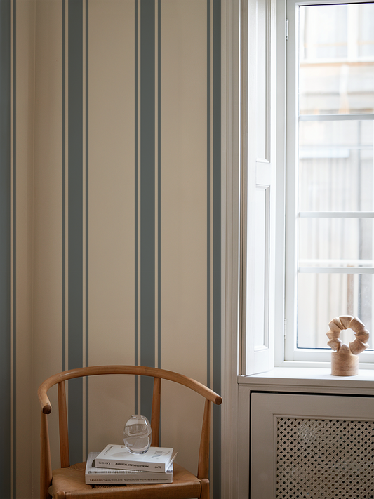 Room interior with striped wallpaper, wooden chair, and window.