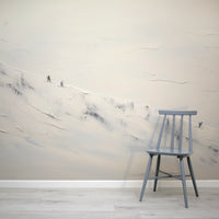 Gray chair against a wall with abstract white and gray patterns