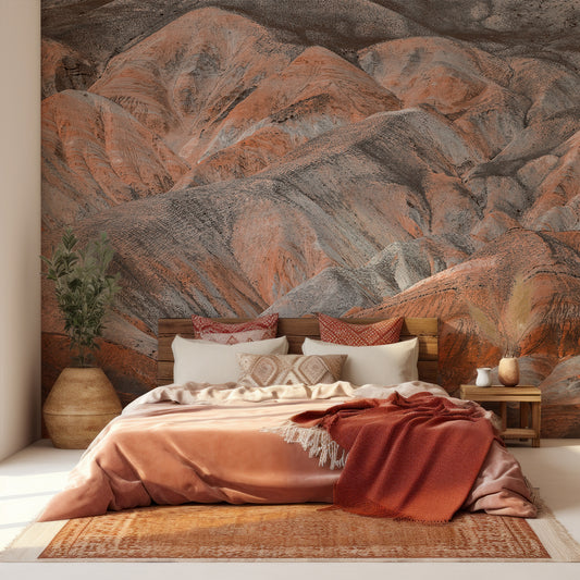 Bedroom with a large mountain mural on the wall, featuring warm colors and decorative pillows.