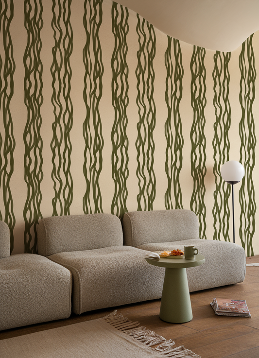 Living room with a beige sofa, green side table, and decorative wall with wavy green patterns.