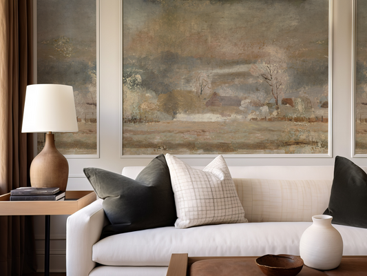 Living room with a beige sofa, decorative pillows, a lamp, and framed landscape painting.